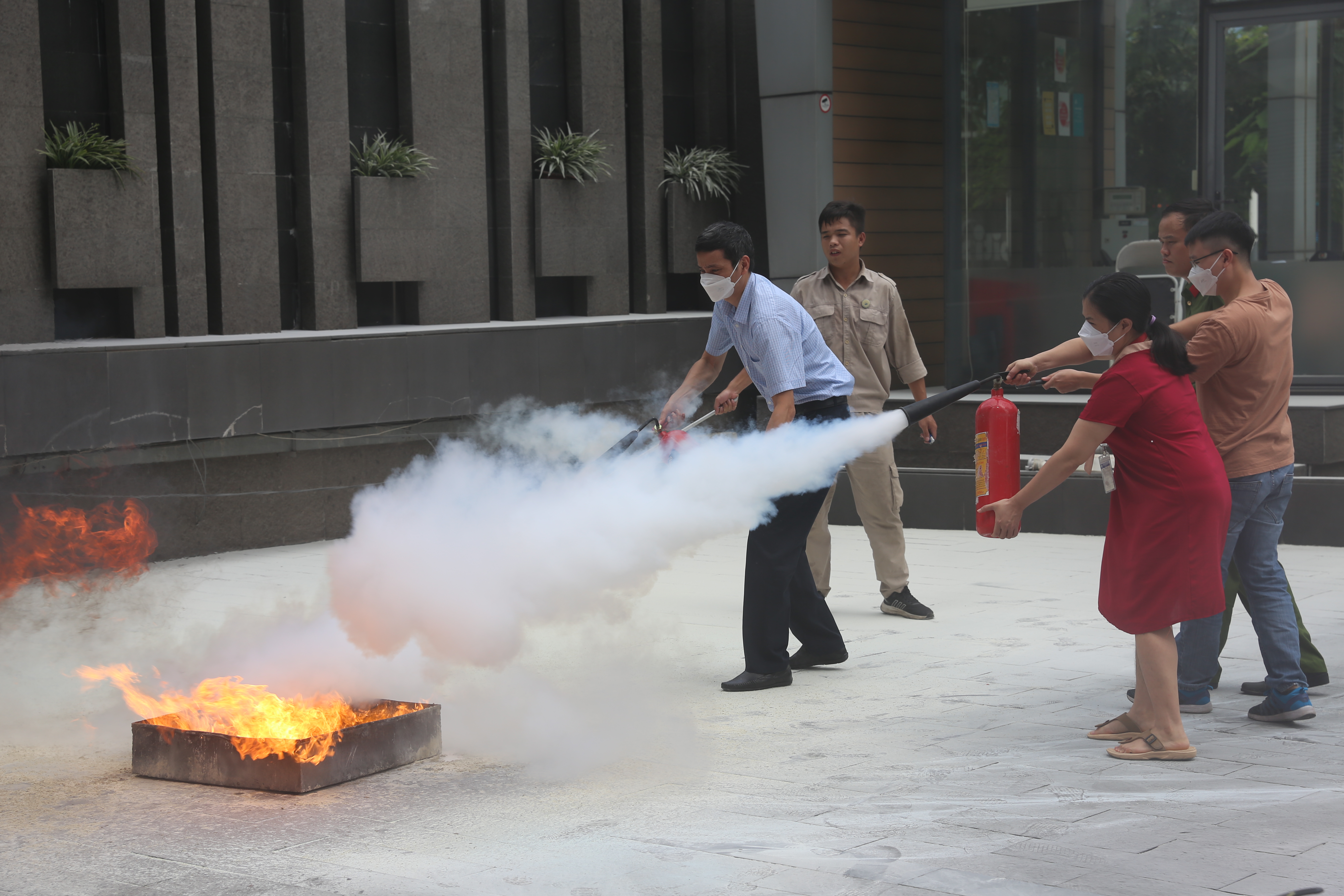 Các học viên thực hành sử dụng bình bột, bình khí CO2 để dập tắt đám cháy