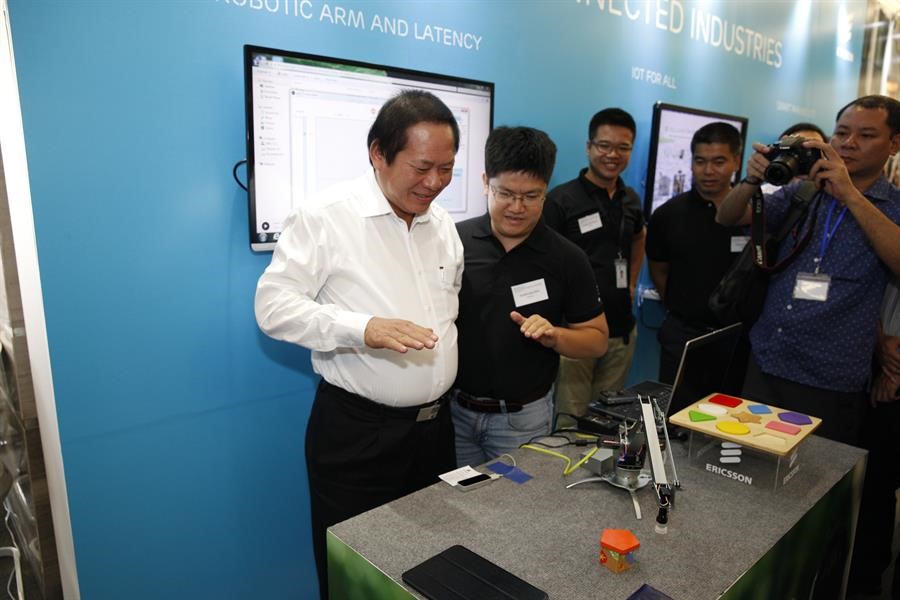 Minister of Information and Communications Truong Minh Tuan controls a robotic arm in real time by the movement of hands and fingers